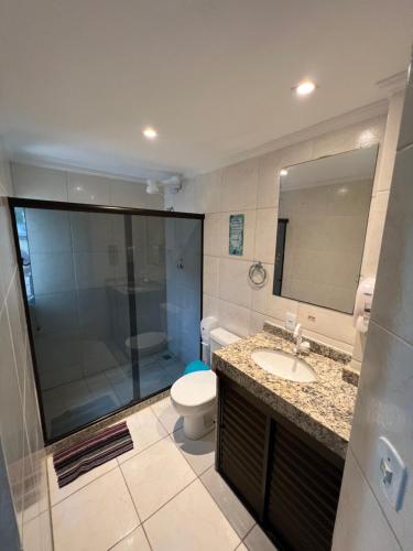 a bathroom with a toilet and a sink and a mirror at Chamos Hostel Cultural in Arraial do Cabo