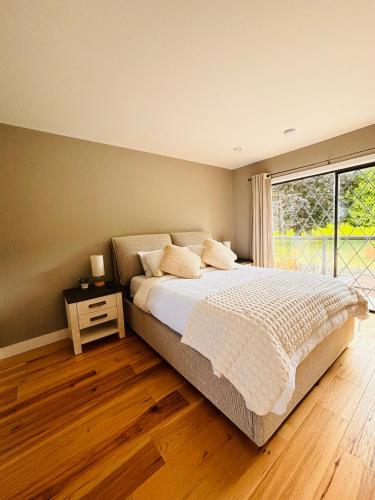 a bedroom with a large bed and a window at Oceanside Manor - Fancy Room - Golf course & Beach View in Qualicum Beach