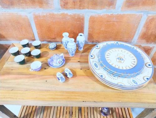 a wooden table with a plate and vases on it at Apatamento 6 in Itatiba