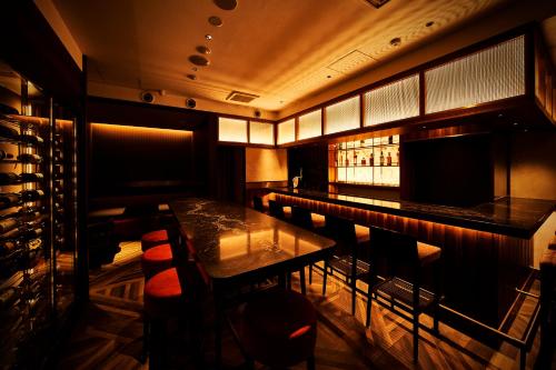 a bar in a restaurant with a table and chairs at The Rise Osaka Kitashinchi in Osaka