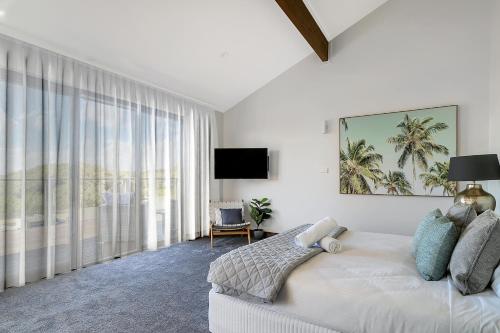 a bedroom with a bed and a large window at Southbeach - Direct Beach Access To Jones Beach in Kiama Downs