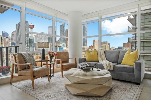 a living room with a view of a city at "The Draper" - Luxury Corner Unit w Tower View, - Near Stampede, Saddledome, BMO Centre! FREE Parking, Banff Pass, & Wine! in Calgary