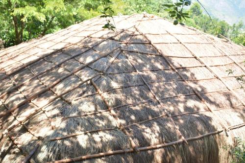 a thatch roof with a net on top of it at Cosmic Mud House Kanthalloor in Kanthalloor