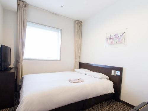 a hotel room with a large bed with a window at Hearton Hotel Higashi-Shinagawa in Tokyo