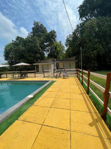 a house with a yellow boardwalk next to a pool at Rajawali Riverside Retreat in Dungun