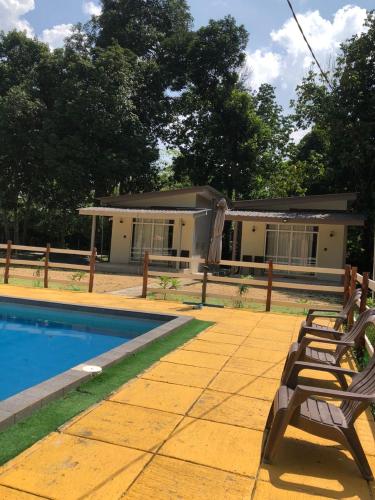 a house with a pool and two benches in front of it at Rajawali Riverside Retreat in Dungun