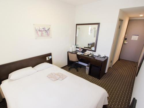 a hotel room with a bed and a mirror at Hearton Hotel Higashi-Shinagawa in Tokyo