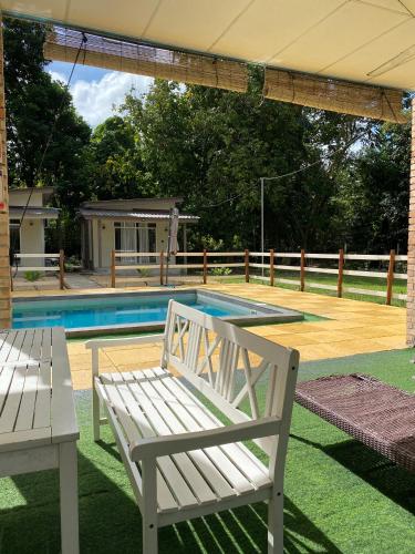 a white bench sitting next to a swimming pool at Rajawali Riverside Retreat in Dungun
