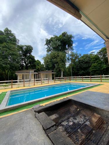an empty swimming pool in front of a house at Rajawali Riverside Retreat in Dungun