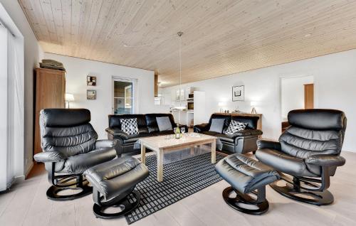 a living room with leather chairs and a table at Holiday Home Kronens Have Tranekær I in Hou