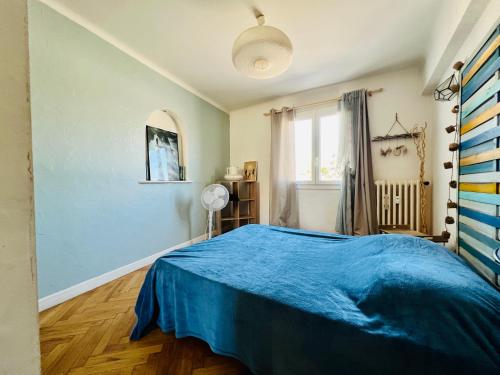 une chambre avec un lit bleu et une fenêtre dans l'établissement 3 Pieces ARENAS NICE OUEST, à Nice