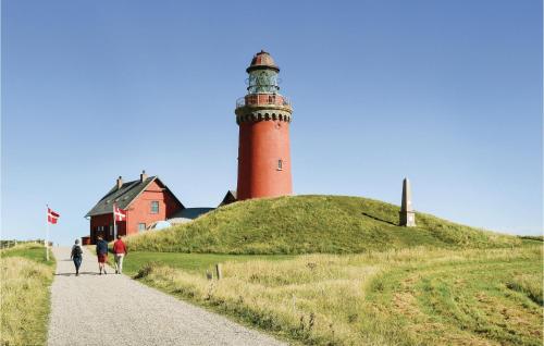 a lighthouse on a hill with people walking down a road at Cozy Home In Lemvig With Wifi in Lemvig