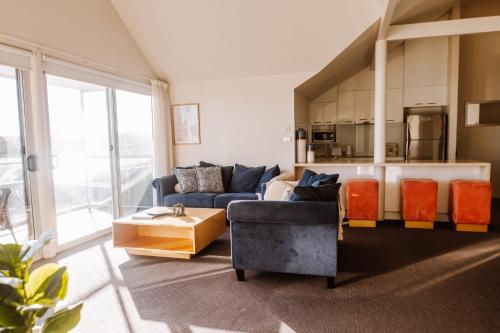 Una sala de estar con un sofá azul y una cocina. en York Cove Hotel, en George Town
