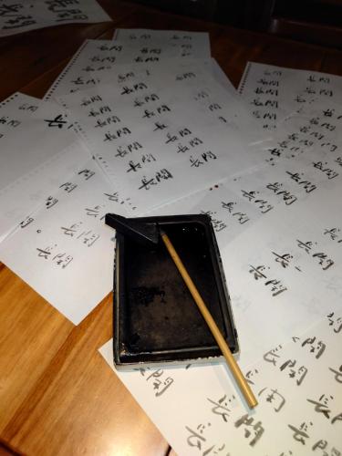 a pencil sitting on top of papers with writing at ゲストハウス長閑 in Toyooka