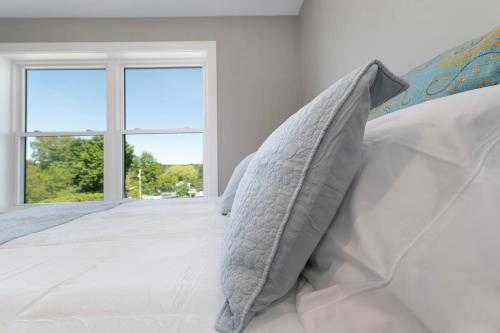 a bedroom with a bed with pillows and a window at The Birches in Lake Leelanau