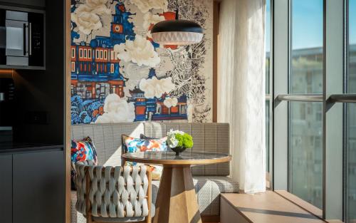 a table and a chair in a room with a window at JEN Kunming by Shangri-La in Kunming