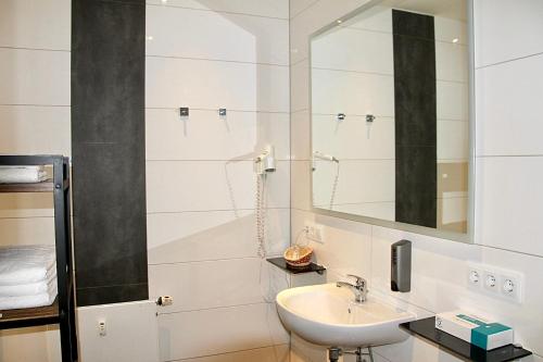 a bathroom with a sink and a mirror at Opera Hotel Köln in Cologne