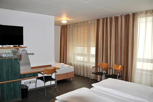 a hotel room with a bed and a desk with chairs at Opera Hotel Köln in Cologne