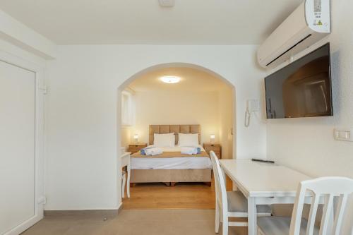 a bedroom with a bed and a table with chairs at All'oro in Njivice
