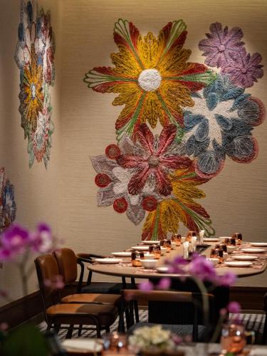a table in a restaurant with flowers on the wall at JEN Kunming by Shangri-La in Kunming