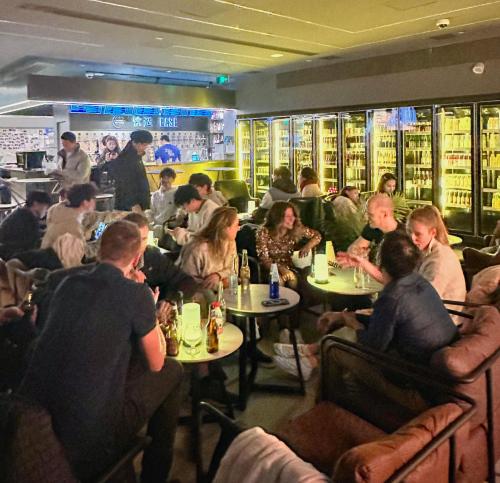 a group of people sitting at tables in a restaurant at Dayin Youth Hostel - East Nanjing Road & People's Square & The Bund -Large Social Area -Bar -Café -Gym -Free Laundry Luggage Storage -24H Front Desk -English Service in Shanghai