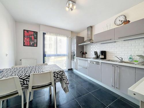 une cuisine avec une table et des chaises dans une pièce dans l'établissement Appartement moderne avec terrasse et parking, au cœur de Granville, à deux pas de la plage ! - FR-1-361-77, à Granville