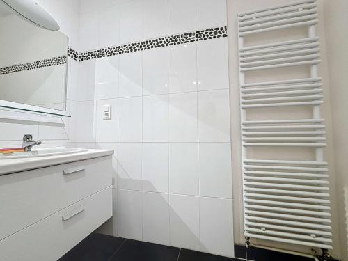 a white bathroom with a sink and a mirror at Appartement moderne avec terrasse et parking, au cœur de Granville, à deux pas de la plage ! - FR-1-361-77 in Granville