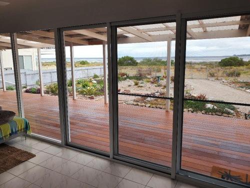 a room with a balcony with a view of the ocean at Beach Front Blue in Coobowie