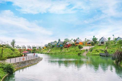 a river with houses on the sides of it at Legacy Hill Resort & Villas in Hòa Bình