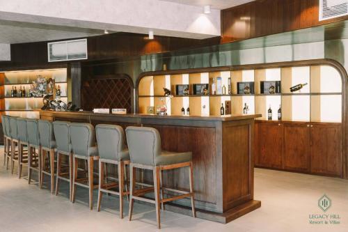 a bar with a row of chairs sitting at it at Legacy Hill Resort & Villas in Hòa Bình