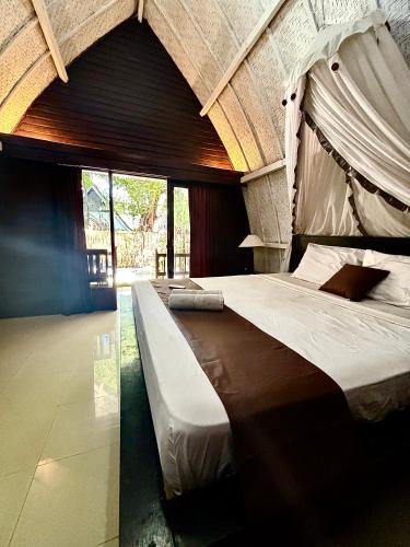 a bedroom with a large bed in a room at Alibaba Bungalows in Gili Islands