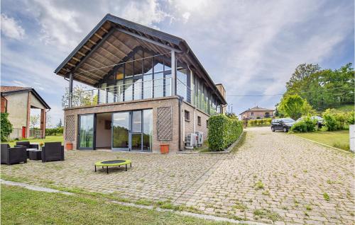 a house with a large window on a brick driveway at Discover Oltrepo in Fortunago