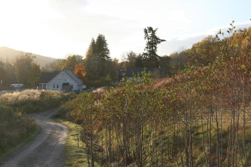 un camino de tierra que conduce a una casa en una colina en BCC Loch Ness Hostel, en Bearnock