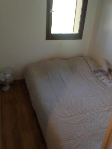 een bed in een kleine kamer met een raam bij Appartement Tout Confort in Morillon