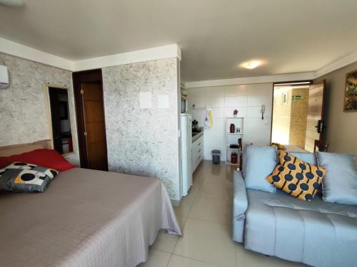 a bedroom with a bed and a couch and a kitchen at VISTA para o MAR e o PÔR DO SOL - MAR BELLO PLAZA in Cabedelo