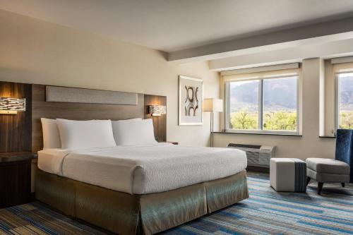 a hotel room with a bed and a window at Holiday Inn Express & Suites Colorado Springs Central by IHG in Colorado Springs