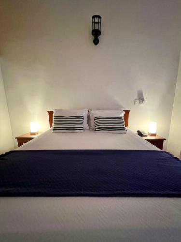 a bedroom with a large bed with two pillows at Hotel Boutique San Antonio in Cali