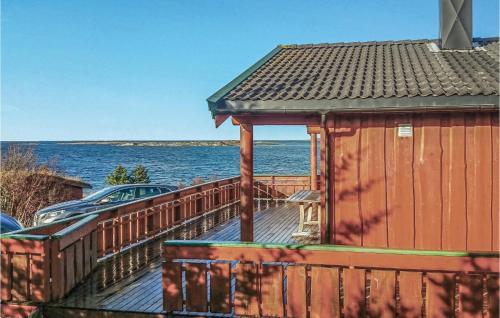 a wooden deck with a building next to the water at Holiday Home Vallersund Nausthylla Haldorhamn in Drilen