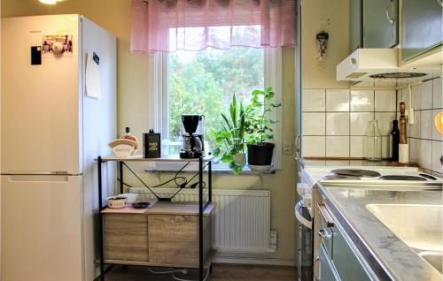 a kitchen with a white refrigerator and a window at Amazing Home In Båstad With Wifi in Båstad