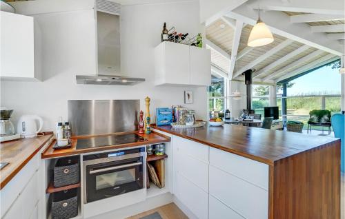 a kitchen with white cabinets and a wooden counter top at Lovely Home In Vordingborg With Wifi in Vordingborg