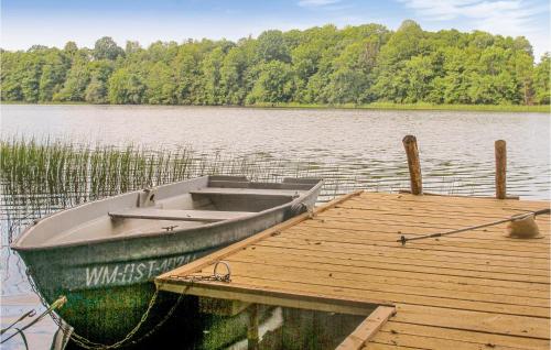a boat tied to a dock on a lake at Three-Bedroom Holiday Home In Milakowo in Miłakowo