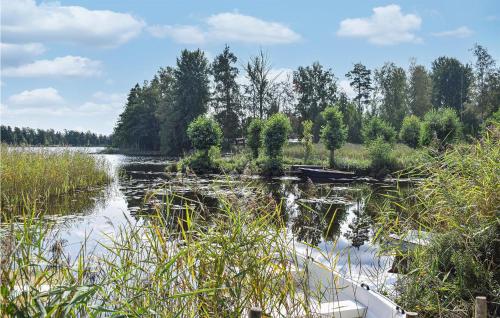 a river with a boat in the water at Cozy Home In Holmsjö With Kitchen in Holmsjö