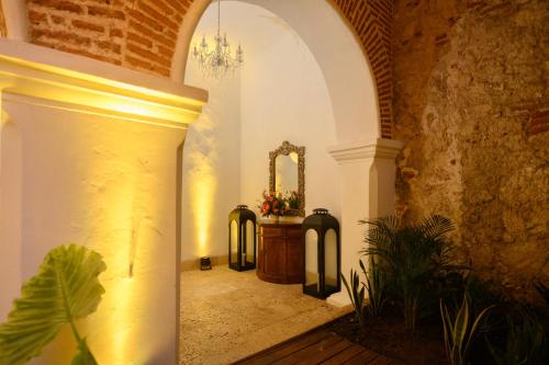 an archway with a mirror and a table in a room at Hotel Casa del Gobernador in Cartagena de Indias