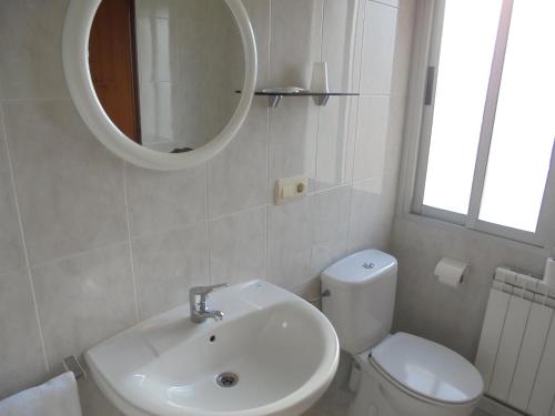 a bathroom with a sink and a toilet and a mirror at Hostal Athlanta in Villalpando