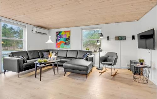 a living room with a couch and a table and chairs at Holiday Home Rømø With Fireplace 06 in Rømø
