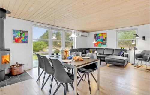 a living room with a table and chairs at Holiday Home Rømø With Fireplace 06 in Rømø