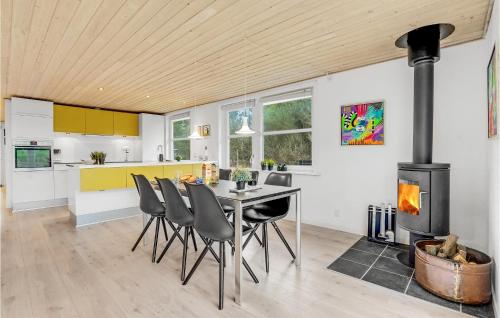 a kitchen with a table and chairs and a stove at Holiday Home Rømø With Fireplace 06 in Rømø