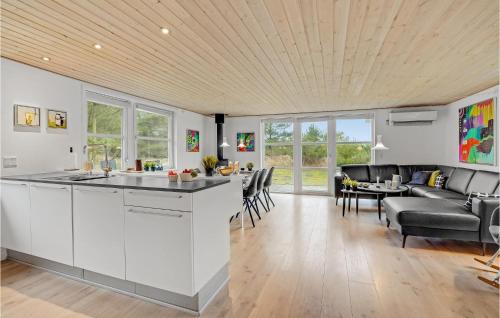 a kitchen and living room with a couch and a table at Holiday Home Rømø With Fireplace 06 in Rømø