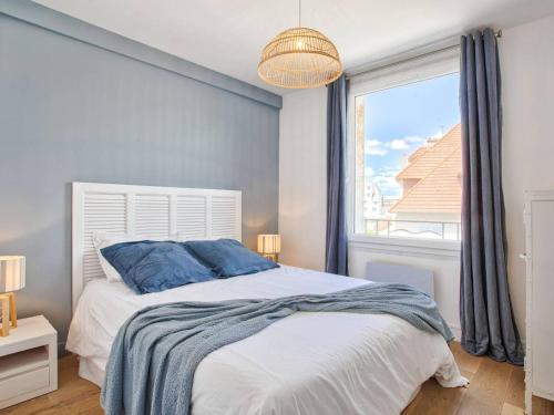 une chambre avec un grand lit et une fenêtre dans l'établissement Appartement en centre-ville de Merville Franceville avec cuisine équipée - FR-1-788-19, à Merville-Franceville-Plage