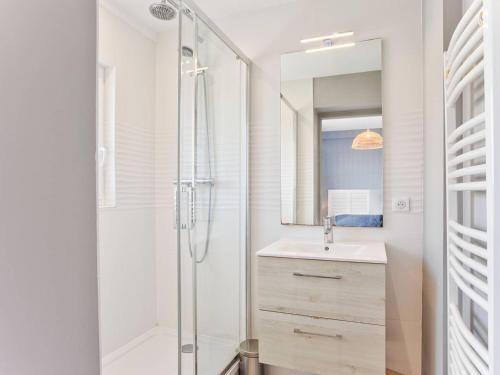 une salle de bain blanche avec une douche et un lavabo dans l'établissement Appartement en centre-ville de Merville Franceville avec cuisine équipée - FR-1-788-19, à Merville-Franceville-Plage
